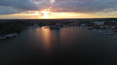 Günbatımında Mikolajki 'ye 4K panoramik hava manzarası - Masurian bölgesinin başkenti. Mikolajskie gölü gün batımı