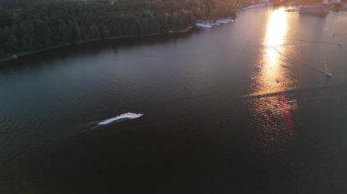 Gün batımında insanların şahsi su araçlarındaki görüntüsü. Gölde jet ski.