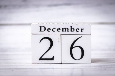 Tatil sonrası 26 Aralık 'ı temsil eden dekoratif bir takvim bloğu. Ahşap bir arka planda ele geçirilen zaman ve yıl sonu kutlamalarını simgeliyor..