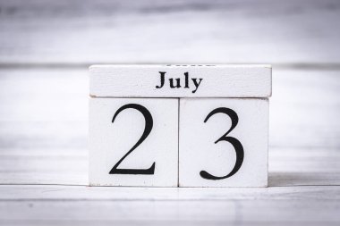 23 Temmuz tarihini gösteren ahşap bir takvimin basit bir resmi. Zaman organizasyonu ve planlama kavramlarını çeşitli bağlamlarda resmetmek için ideal.