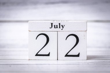 22 Temmuz tarihini gösteren iki tahta takvim bloğu yaz mevsimini ve önemli olayları temsil ediyor. Etkinlik promosyonları veya mevsimlik pazarlama kampanyaları için ideal.