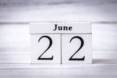 22 Haziran 'ın yıl ortası planlamasını simgeleyen ahşap bir takvim. Bu resim, zaman yönetimi veya mevsimsel faaliyetlerin planlanmasında görsel bir ipucu olarak kullanılabilir.