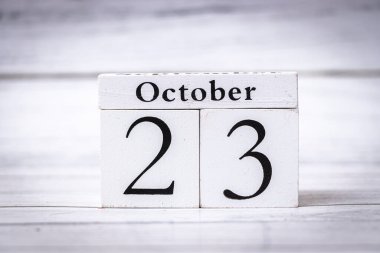 Tarihi 23 Ekim olarak gösteren tahta bir takvim mevsimsel bir değişimi yansıtıyor. Bu resim sonbaharda etkinlikler ve kutlamalar için idealdir..