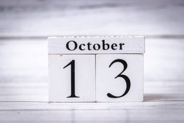 13 Ekim tahtadan bir takvim bloğunda sergileniyor ve tarihi tertemiz minimalist bir şekilde vurguluyor. Zaman yönetimi veya zaman çizelgelerini göstermek için ideal.