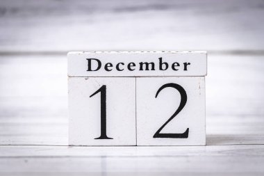 Tahta takvim 12 Aralık 'ı gösteriyor. Zarif tasarım, mevsimsel temalar, tatil dekorasyonları veya etkinlik planlama için uygun bir kırsal dokunuş ekler.