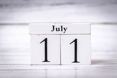 11 Temmuz tarihini gösteren bir takvim bloğu. Siyah sayılı beyaz bloklar ev dekoru veya ofis ayarları için uygun klasik bir estetik sunar.