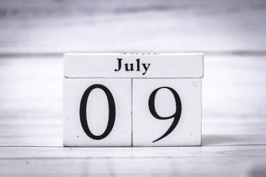 9 Temmuz 'un yaz ortası günlerini sembolize eden ahşap bir takvimin yakın çekimi. Bu resim çeşitli temalar için uygun organizasyon ve zaman yönetimi duygularını çağrıştırır.