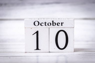 Tahta bir takvim bloğu 10 Ekim 'de hafif ahşap bir arka planda tarihi gösteriyor. Etkinlik anımsatıcıları ve mevsimsel temalar için ideal.