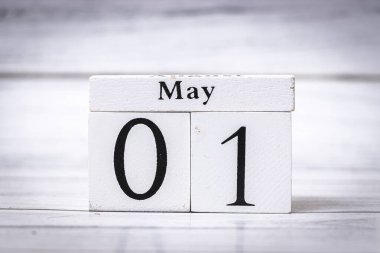 01 Mayıs tarihini gösteren ahşap bir takvim bloğu. Minimalist beyaz arkaplan, yeni ayın başlangıcını belirten tarihe odaklanmayı artırır.