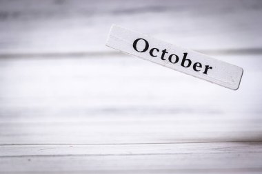 Ekim ayında, güz mevsimini ve hasat kutlamaları ve şenliklerle ilgili ayı sembolize eden ahşap bir arka plan üzerine yazılmış el yazısı..