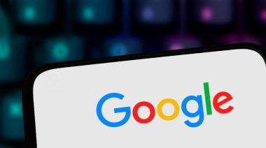 Varşova Polonya - 8 Kasım 2025: Google logosunu ekranında gösteren akıllı telefonun yakın çekimi, küresel çapta tanınan arama motorları arayüzünün teknolojiyi vurguluyor.