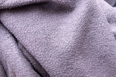 Yumuşak desenli kumaşın iç tasarım ya da el işi projelerinde kullanılmak için ideal sönük mor renkte yakın çekimi. Çeşitli tasarımlara zarafet katmak için mükemmel.