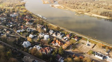 Kazimierz Dolny 'nin nehir kıyısı boyunca büyüleyici evler sergilediği görkemli bir hava manzarası. Bu tarihi bölgenin sakinliğini ve güzelliğini yansıtan gür ağaçlarla çevrili..
