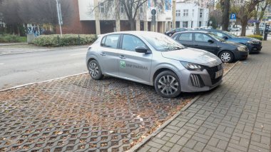 Rzeszow Polonya - 16 Kasım 2025: BNP Paribas 'tan gümüş renkli bir araba kaldırım taşlı bir sokağa park edilmiş ve şehir ortamında yaprakları dökülmüş..