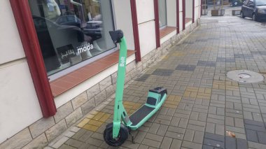 Rzeszow Polonya - 16 Kasım 2025: Bolt 'tan parlak renkli bir elektrikli scooter şehir kaldırımına park edildi..