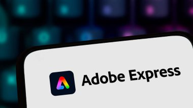 Varşova Polonya - 8 Kasım 2025: Modern tasarım sergilenen bulanık renkli klavye arka planına karşı Adobe Ekspres logosunu gösteren akıllı telefon ekranının yakın çekimi.