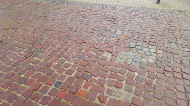 Kırmızı ve gri taşların çeşitli tonlarının yer aldığı kaldırıma yakın çekim görüntüsü. Doku, arka planlar için ideal bir köy tarihi şehir yolunu gösteriyor..