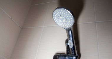 Çağdaş ev tasarımında ferahlatıcı ve canlandırıcı bir duş deneyimi sağlayan fayanslı banyo duvarına monte edilmiş birden fazla su püskürtüleri olan duş başlığı..