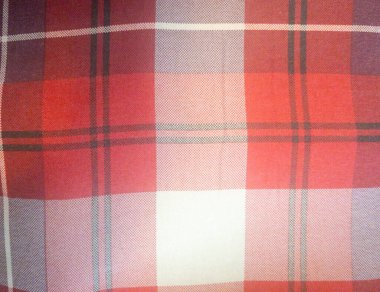 Bu resim canlı kırmızı bir ekose kumaşın yakın çekimini gösteriyor. Karmaşık desen, giysi ve ev dekorunda sıkça kullanılan dokusunu vurgular..