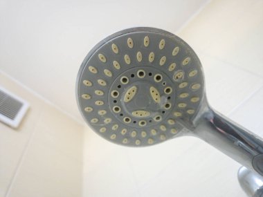 Modern duş başlığının çok sayıda su çıkışı deliği olan yakın görüntüsü benzersiz bir bakış açısı sağlıyor. Ev geliştirme ve tesisat temaları için ideal.