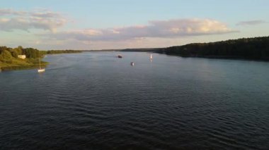 Günbatımında Mikolajki yakınlarında yüzen yelkenli ve kargo gemisinin yer aldığı Masuria 'nın sakin sularının hava görüntüsü bölgenin doğal güzelliğini gözler önüne seriyor..