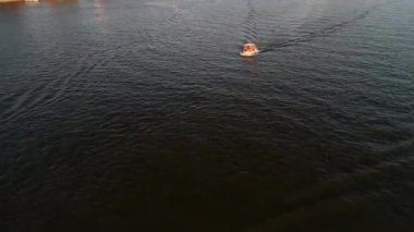 Mikolajki, Polonya, 9 Ağustos 2024: Serin yeşillik ve sakin manzaralarla çevrili, ışıldayan bir gölün dalgalı sularında gezinen bir tekne