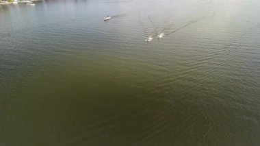 Mikolajki, Polonya 9 Ağustos 2024: Geçen bir tur teknesinin yakınındaki iki jet ski 'nin havadan görünüşü