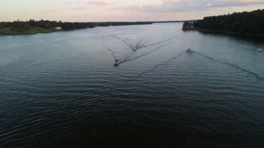 Mikolajki, Polonya, 9 Ağustos 2024: Masuria bölgesi gölünde gezinen teknelerin manzarası, yaz akşamları güzel sular ve sakin manzaralar sergiliyor