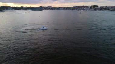 Mikolajki, Polonya, 9 Ağustos 2024: Bir tekne Mikolajskie Gölü 'nün sakin sularında hızla ilerliyor, Masuria' nın yemyeşil ve manzaralı manzaralarıyla çevrili.