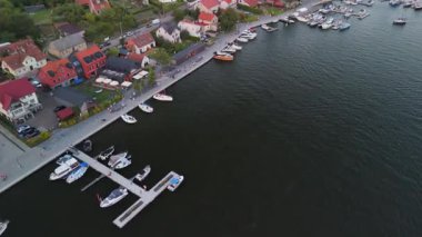 Mikolajki, Polonya, 9 Ağustos 2024: Bir hava manzarası, Mikolajki 'nin Masuria' daki güzel marinasını sergiliyor, yatlarla dolup taşıyor ve büyüleyici deniz manzaralı evlerle çevrili.
