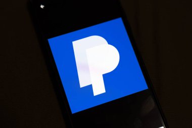 Varşova Polonya - 4 Aralık 2025: PayPal logosunun yakın çekimi, mavi arka plana karşı modern dijital ödeme çözümlerini gösteren bir telefon ekranında sergilendi.