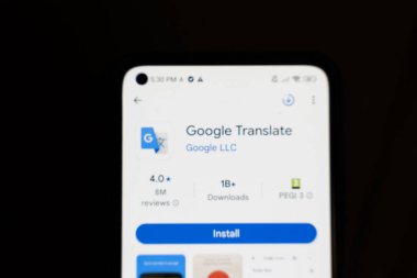 Varşova Polonya - 4 Aralık 2025: Google Çevirisi uygulamasını gösteren bir akıllı telefon ekranının kapanışı İndirme ve yükleme seçenekleri koyu arkaplana karşı.