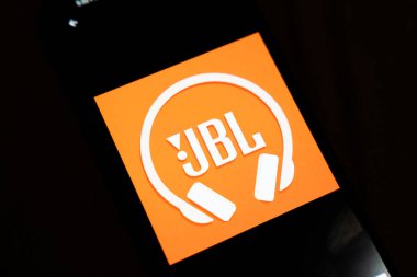 Varşova Polonya - 4 Aralık 2025: Akıllı telefon ekranında sergilenen JBL logosu, markanın müzik severlere yönelik ses ekipmanları ve kulaklıklara olan ilgisini vurguluyor.