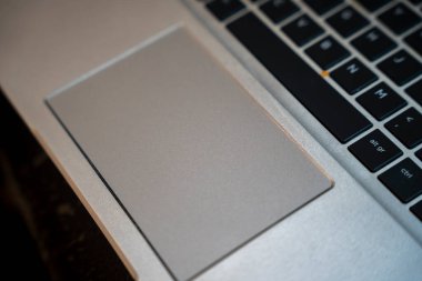 Modern teknoloji ve tasarımın iş eğitimi ve teknolojiyle ilgili uygulamalar için ideal olduğunu gösteren parlak bir dizüstü bilgisayara ve klavyeye yakın çekim.