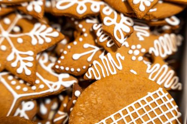 Çok güzel dekore edilmiş, çeşitli şekillerde zencefilli kurabiyeler. Karmaşık beyaz krema kalıpları sergiliyorlar. Noel kutlamaları ve şenlikli mutfak pazarlaması için ideal..