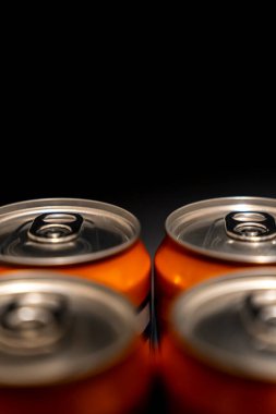 Yukarıdan görülen dört turuncu meşrubat kutusunun yakın plan görüntüsü. Belirgin çekiş etiketleri karbonatlı içeceklerin ferahlatıcı doğasını gözler önüne seriyor..