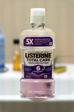 Varşova Polonya - 16 Aralık 2025: Listerine Total Care gargara şişesinin yakından çekimi diş koruma özelliklerini ve bir banyo ortamında yerleştirilen antibakteriyel faydaları vurguluyor.