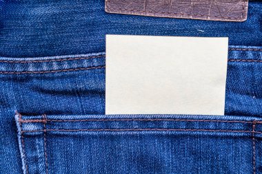 Kot pantolonun arka cebine, basitliği ve kişisel dokunuşu sembolize eden boş bir kağıt parçası yerleştirilmiş. Not iletileri veya yaratıcılık kavramları için ideal.