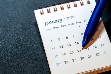 Ocak 2026 'da gösterilen bir takvim sayfasının yakın görüntüsü. 21 Ocak 'ta mavi bir kalem dinleniyor ve planlama amacıyla bu tarihi vurguluyor. Zaman yönetimi görüntülemesi için kullanışlı.