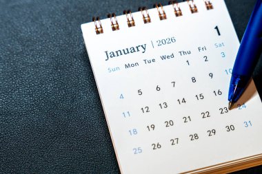 Ocak 2026 'da 23' ü daire içine alınmış bir takvimin yakın çekimi. Takvimin yanında planlama ve organizasyonu sembolize eden mavi bir kalem duruyor.