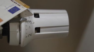 Kışın ısıtma ve enerji faturalarına yapılan ev harcamalarını gösteren bir radyatör ızgarasının üzerinde dinlenen Euro banknotları