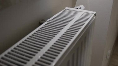 Ev yapımı radyatör ızgarasına yerleştirilen eller, ısıtma performansı ve günlük enerji kullanımını ve kış boyunca konut ısıtma koşullarını yansıtan iç ısıyı gösteriyor.