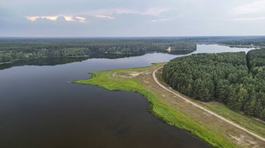 Bereketli yeşil ormanlar ve çayırlarla çevrili sakin bir göl manzarası günbatımına yakın güzellik ve huzuru gözler önüne seriyor..