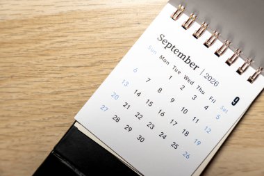 Eylül 2026 tarihli bir takvim sayfasının ayrıntılı görüntüsü ahşap bir masa arkaplanının içinde gün ve tarihleri gösteriyor. Planlama ve zaman yönetimi görselleri için ideal.
