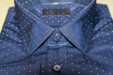 Yakından bakınca, beyaz benekli lacivert gömleğin yaka detaylarını gösteriyor. Moda markaları ve giyim reklamları için mükemmel..