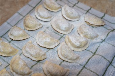 Damalı bir bezin üzerine serpiştirilmiş un serpiştirilmiş el yapımı hamur tatlısı. Bu geleneksel yemek pişirme becerileri sergiliyor. Gıda ile ilgili projeler ya da kültürel pazarlar için mükemmel.