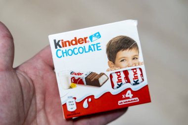 Varşova Polonya - 16 Aralık 2025: Çocuklar için eğlenceli ve keyifli doğayı vurgulayan gülümseyen bir çocuğun yer aldığı Kinder Çikolata kutusunun yakın çekimi.