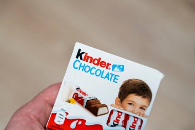 Varşova Polonya - 16 Aralık 2025: Gülümseyen bir çocuğun şekerleme sergilediği bir Kinder Çikolata Paketi. Gıda endüstrisinde reklam ve pazarlama için ideal..