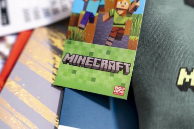 Varşova Polonya - 16 Aralık 2025: Renkli oyunlarla ilgili malzemeler arasında pikselli karakterlerin yer aldığı bir Minecraft oyununun tanıtım kartının yakın çekimi. Oyun kültürünün canlı bir temsili..