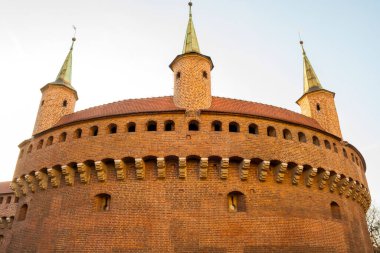 Krakow Polonya - 17 Şubat 2019: Krakow 'un kalbinde ortaçağ mimarisi ve kültür mirası sergilenen belirgin kuleleri ve tuğla cepheli tarihi Barbika yapısı.